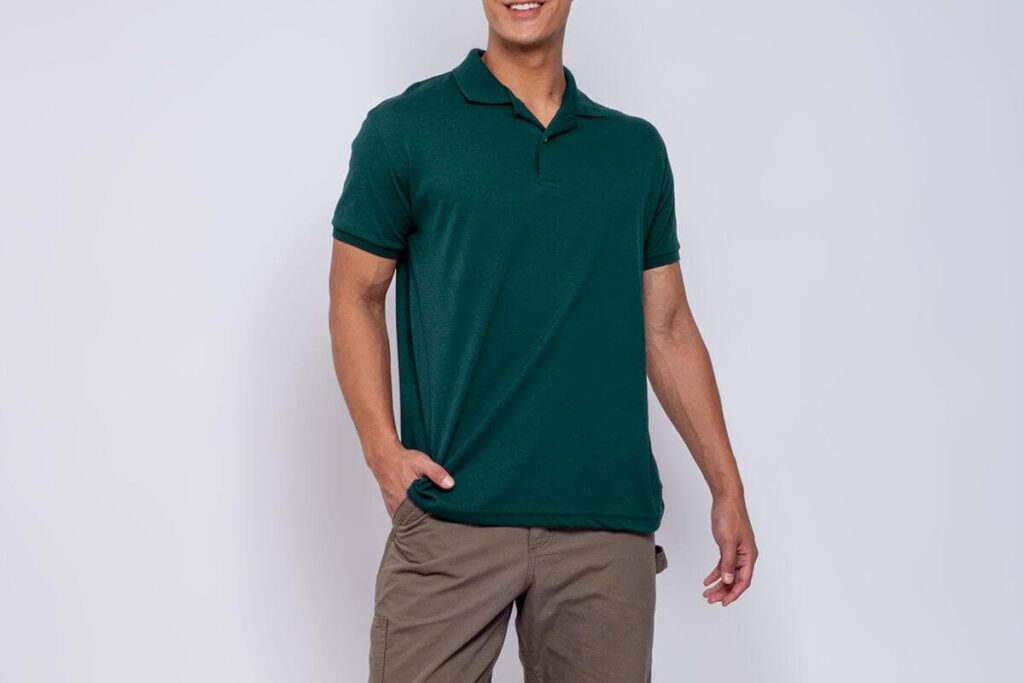 Man modeling a dark green plain polo shirt with khaki cargo pants against a neutral studio background