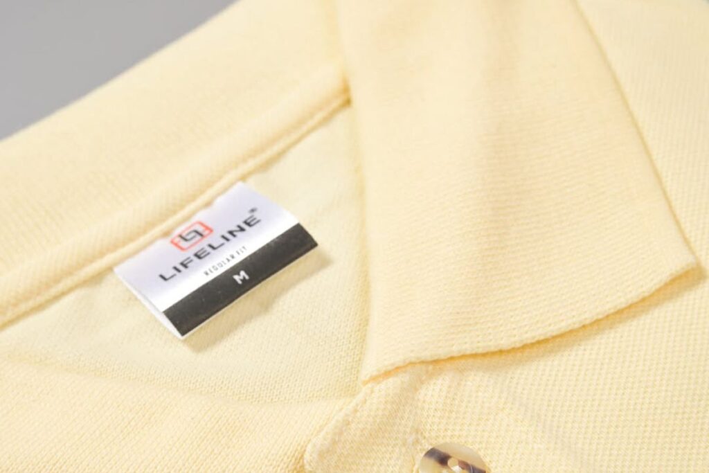 Close-up of yellow Lifeline polo shirt collar and fabric label