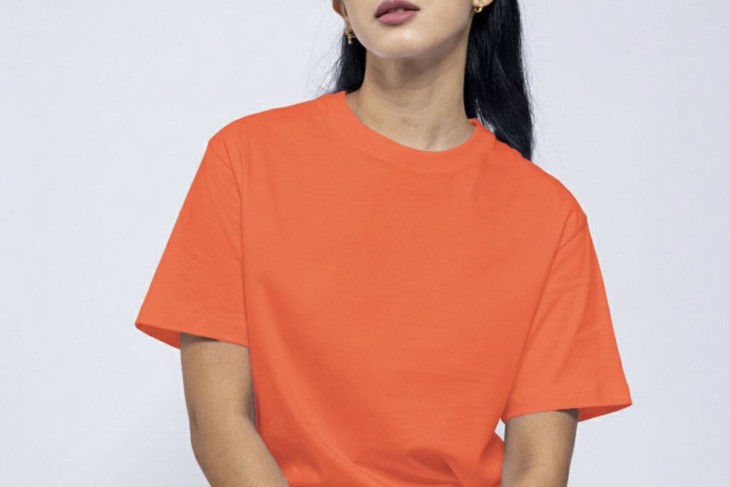 Female model wearing an orange plain round neck shirt with a relaxed casual fit